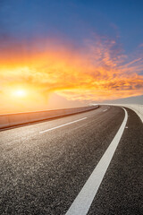 Asphalt road and colorful sky clouds at sunset