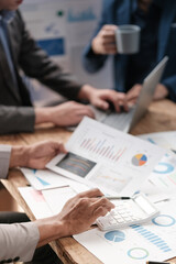 Close up group of business men and woman discussion and brainstorming, bookkeeping audit graph and chart documents at desk, teamwork concept.