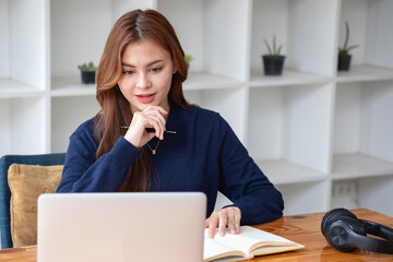 Happy young Latin female college student studying online remotely Distance university webinars Or video call on your laptop and use your computer for a virtual meeting seminar at home or on campus.