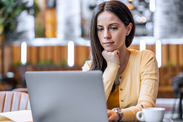 Woman using laptop at cafe