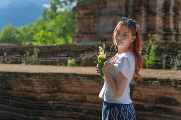 Pretty Asian tourists woman wearing beautiful hand-woven clothes dyed with indigo and mud-fermented...