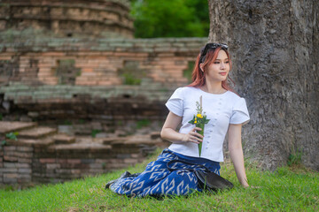 Pretty Asian tourists woman wearing beautiful hand-woven clothes dyed with indigo and mud-fermented...