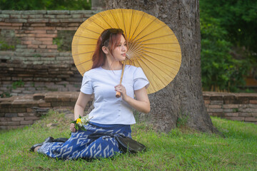 Pretty Asian tourists woman wearing beautiful hand-woven clothes dyed with indigo and mud-fermented...