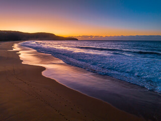 Sunrise seascape with waves and a low cloud bank