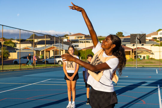 aboriginal girl shooting goal in netball team