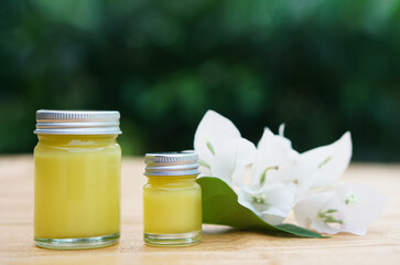 Bottles of homemade Thai herbal ointment.Decorated with white flowers.Concept, Thai local wisdom to use  fragrant medicinal herbs to make inhaler and massage balm.                        