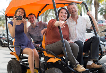family of tourists enjoy a walk on the bike carriage