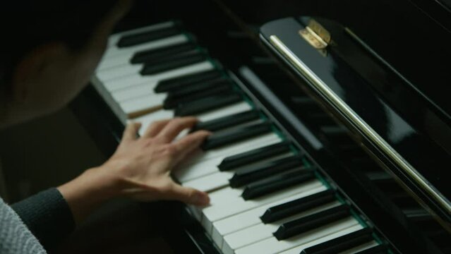 female playing piano in her home. Cinematic setting. classical music in slow motion. 