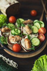 Black bread sandwiches with sauce, greens and fried sausages. A hearty dish