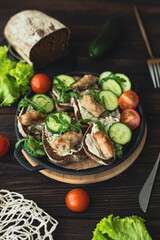 Black bread sandwiches with sauce, greens and fried sausages. A hearty dish