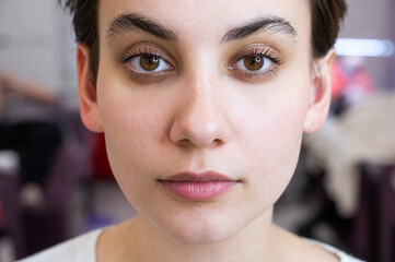 Portrait of a caucasian woman after eyelash lamination procedure. 