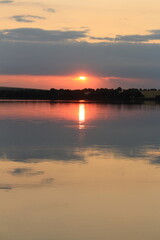 A body of water with a sunset in the background