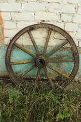 Fototapeta na wymiar A wooden wheel on grass