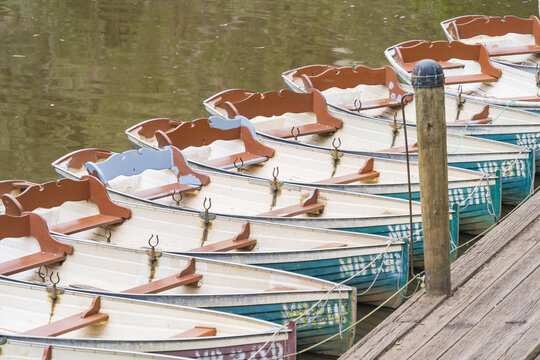 A row of identical row boats lined up at a dock