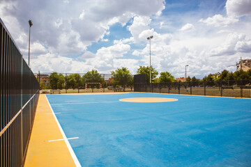 Empty outdoor basketball court and blue sky. Blue basketball court for soccer, outside in sunny...