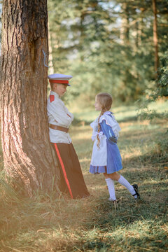 A beautiful love story. Boy and girl in love. Pupils. Lyceum students. Vintage. A beautiful girl and a beautiful boy in uniform. Tenderness. The boy gently holds touched the girl's hand. blond long 