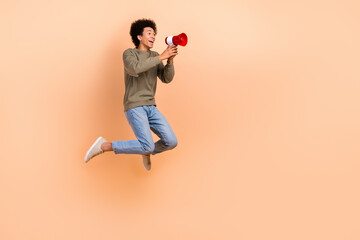Fototapeta na wymiar Full length profile photo of active energetic person jump hold loudspeaker empty space isolated on beige color background