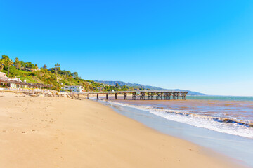 Fototapeta na wymiar Malibu Beachscape: Wooden Pier, Sandy Shore and Coastal Homes