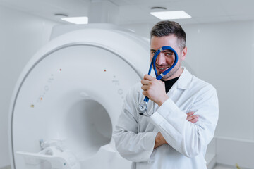 Fototapeta na wymiar MRI scanner. Portrait of a male doctor with a stethoscope against the background of professional diagnostic equipment.