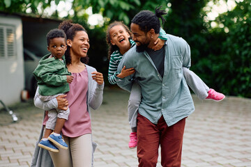 Happy black parents with kids enjoy in family day outdoors.