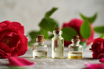 Bottles of essential oil with fresh blooming roses