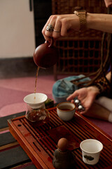 Fototapeta na wymiar person pouring tea in a pot, in the style of influenced by ancient chinese art, low key