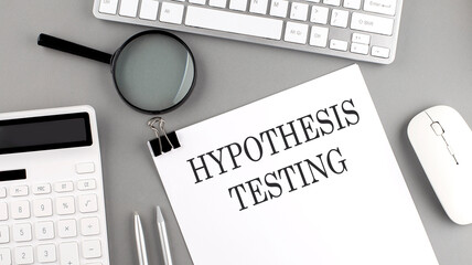 Hypothesis testing written on paper with office tools and keyboard on the grey background - obrazy, fototapety, plakaty