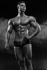 Fototapeta na wymiar Bodybuilder showing off his perfect low fat body without clothes in studio