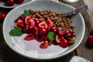 Granola with yogurt and cherries in a bowl
