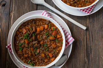 Rustic beef lentil stew on wooden table