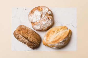 Assortment of freshly baked bread with napkin on rustic table top view. Healthy unleavened bread. French bread