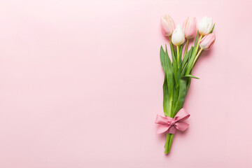 Bouquet of pink tulips on colored table background . Top view with copy space. Waiting for spring. Happy Easter card. Flat lay