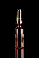 Medicine ampoule with reflexion on a black background. 