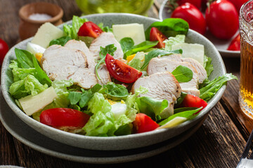 Salad of chicken fillet, eggs, tomatoes and cheese in a plate. Caesar salad