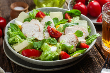 Salad of chicken fillet, eggs, tomatoes and cheese in a plate. Caesar salad