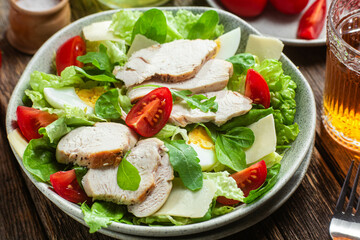 Salad of chicken fillet, eggs, tomatoes and cheese in a plate. Caesar salad