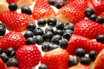 Round cream cake with berries, blueberries, strawberries, top view close up background.