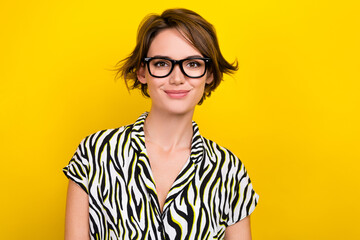 Portrait of adorable positive cheerful woman with short haircut wear striped blouse glasses smiling isolated on yellow color background