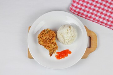 Crispy fried chicken served with rice and chilli sauce on a white plate