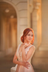 Beautiful slender girl in an evening dress. Prom. Graduate. Schoolgirl. Student. Girl with long red hair. Portrait of a girl. Girl dancing. Tenderness. Fashionable girl.