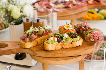 French sandwiches with ham tomatoes, avocado and microgreens. Catering in the office. Table with canapes and various snacks served at a banquet.