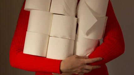 A human is stocking up on toilet paper for the home. A woman holds rolls of paper in hands. Hygiene remedy for illness and diarrhea