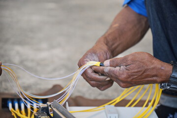 Technician is using duct tape. with fiber optic cable before installing into the FTTH terminal box.
