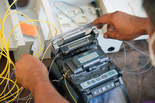Technician working, fiber optic cable splicing and testing cables with optical power meter 