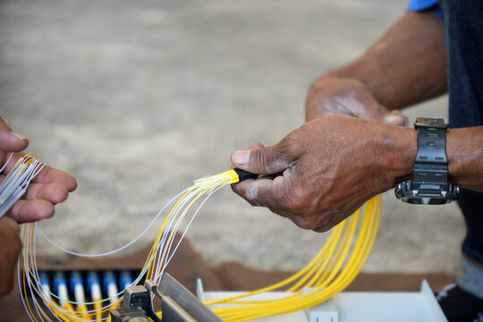 Technician is using duct tape. with fiber optic cable before installing into the FTTH terminal box.