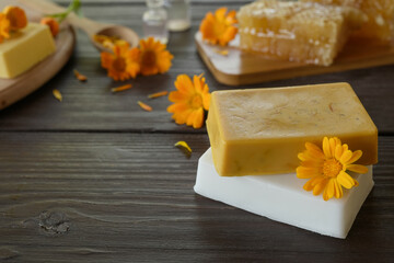 Natural handmade soap with calendula (pot marigold), oil essential and honeycomb on rustic wooden background. Healthy skin care. SPA concept. Side view, copy space for text.