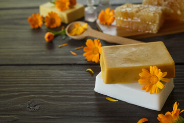 Natural handmade soap with calendula (pot marigold), oil essential and honeycomb on rustic wooden background. Healthy skin care. SPA concept. - obrazy, fototapety, plakaty