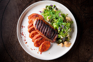Roasted Duck breast fillets with vegetable salad and batat in plate