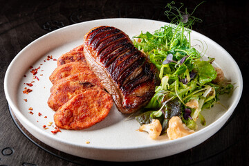 Roasted Duck breast fillets with vegetable salad and batat in plate