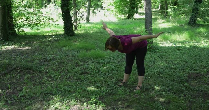 50 Year Old Mid Adult Woman Doing Neck And Upper Spine Exercise Outdoors, Making Swimming Moves, Real People, Steadicam